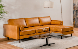 There is a textured, tan leather sofa in the living room.