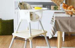 A baby high chair next to the dining table